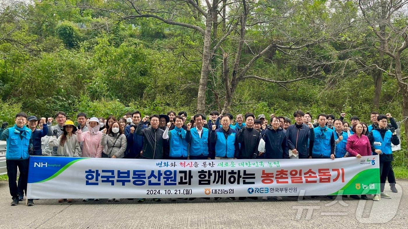 농협 대전본부와 한국부동산원 충청지역본부, 산내농협 임직원들이 농촌일손돕기에 앞서 기념사진을 촬영하고 있다.&#40;농협 대전본부 제공&#41; / 뉴스1 