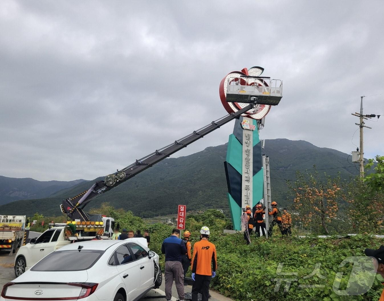 21일 오전 9시 50분쯤 밀양시 산내면 24번 국도에서 승용차가 광고판 교체 작업 중이던 3.5톤 크레인을 추돌해 고립된 작업자 2명을 소방이 구조하고 있다.&#40;밀양소방서 제공&#41;