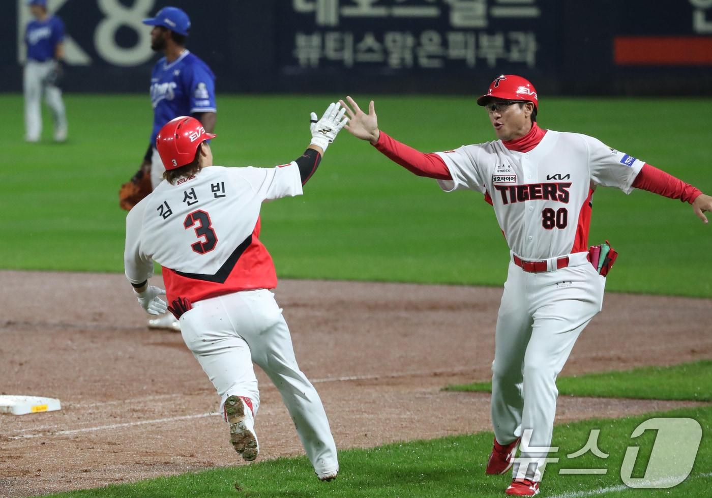 21일 오후 광주 기아챔피언스필드에서 열린 프로야구 &#39;2024 신한 SOL 뱅크 KBO 포스트시즌&#39; 한국시리즈 1차전 삼성 라이온즈와 KIA 타이거즈의 경기, 2회말 KIA 공격 2사에서 김선빈이 좌익수 방향 큼지막한 타구를 날린 후 홈런으로 판단하고 1루코치와 하이파이브를 하고 있다. 비디오 판독 결과 3루타. 2024.10.21/뉴스1 ⓒ News1 오대일 기자