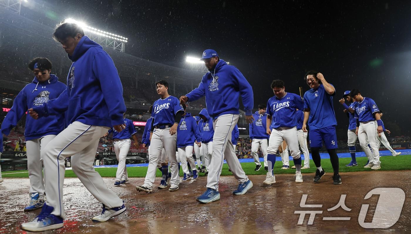 21일 오후 광주 북구 기아챔피언스필드에서 열린 프로야구 &#39;2024 신한 SOL 뱅크 KBO 포스트시즌&#39; 한국시리즈 1차전 삼성 라이온즈와 기아 타이거즈의 경기, 삼성 선수들이 6회초 무사 1,2루 우천중단 상태에서 서스펜디드 경기가 선언되자 관중에게 인사 후 이동하고 있다. 2024.10.21/뉴스1 ⓒ News1 김도우 기자