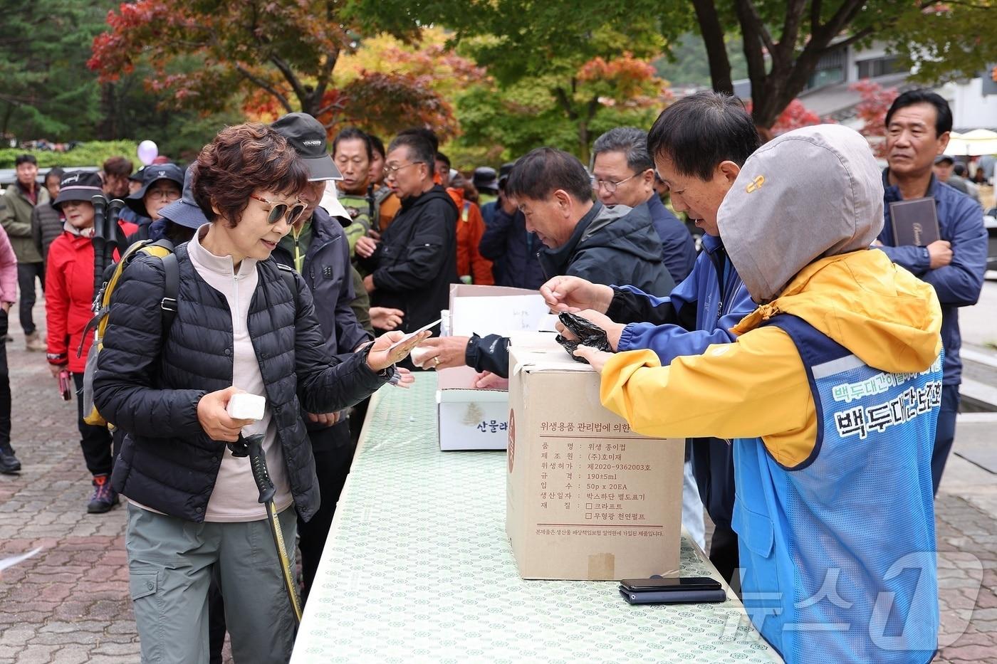 완연한 가을 날씨를 보인 26일 백두대간 두타산 자락 동해 무릉계곡을 방문한 단풍객들이 인근에서 열린 산삼심기 대회에 참가하기 위해 묘삼을 받아가고 있다.&#40;동해시 제공&#41; 2024.10.26/뉴스1