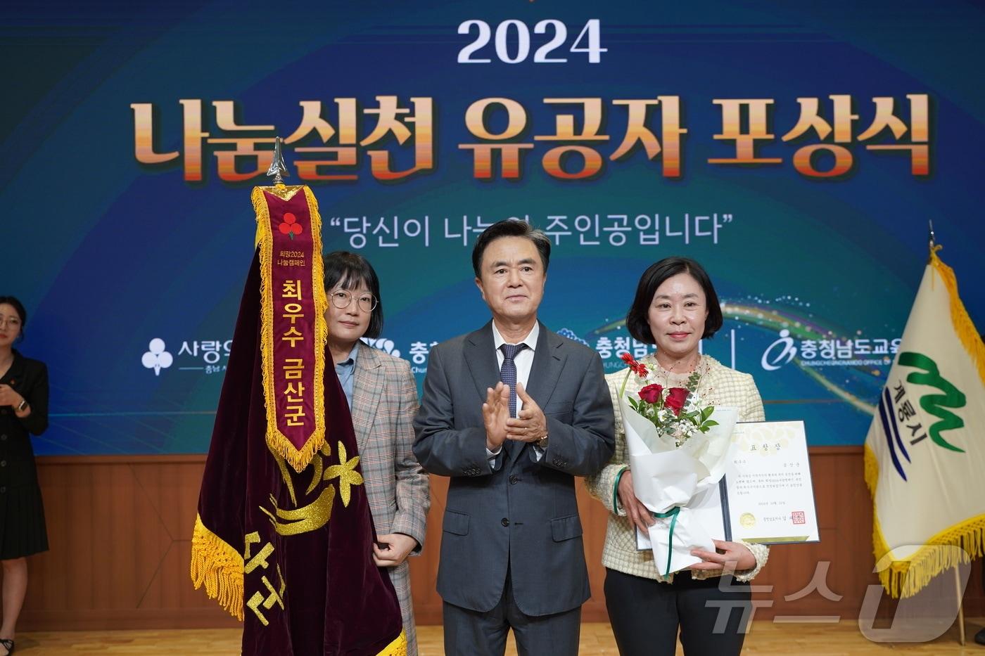 지난 25일 충남도청에서 있은 2024 나눔실천 유공자 포상식에서 최우수기관 선정된 금산군의 강미향 주민복지지원과장&#40;오른쪽&#41;이 김태흠 충남도지사&#40;가운데&#41;로부터 표창장을 받은 후 기념사진을 찍고 있다. &#40;금산군 제공&#41;/ 뉴스1 