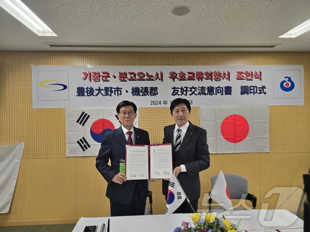 정종복 기장군수&#40;왼쪽부터&#41;와 카와노 후미토시 분고오노시 시장이 우호교류의향서를 체결하고 기념촬영을 하고 있다&#40;기장군청 제공&#41;