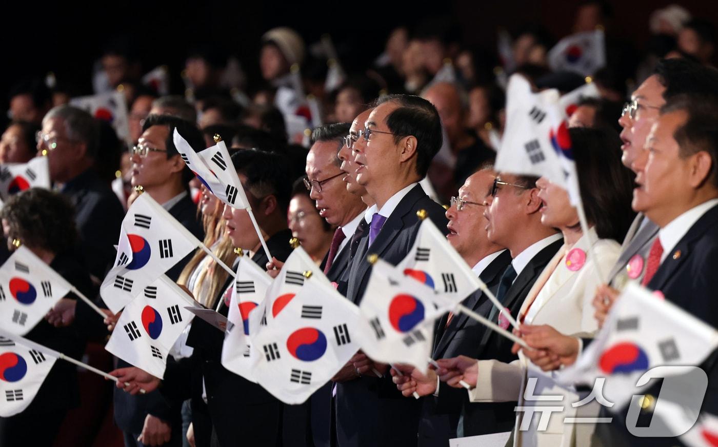 한덕수 국무총리가 9일 오전 서울 종로구 세종문화회관에서 열린 &#39;제578돌 한글날 경축식&#39;에서 태극기를 들고 한글날 노래를 제창하고 있다. 2024.10.4/뉴스1 ⓒ News1 황기선 기자