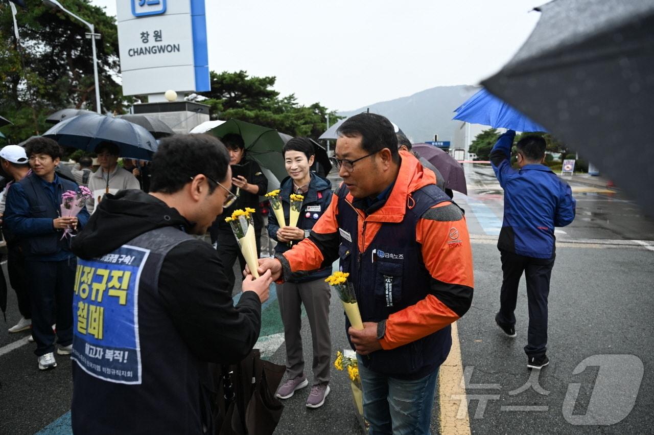 1일 오전 7시 30분쯤 한국지엠 창원공장 앞에서 금속노조 경남지부가 이날 첫 출근에 나선 한국지엠 비정규직 노조 조합원들에게 꽃송이를 전하고 있다.&#40;금속노조 경남지부&#41;