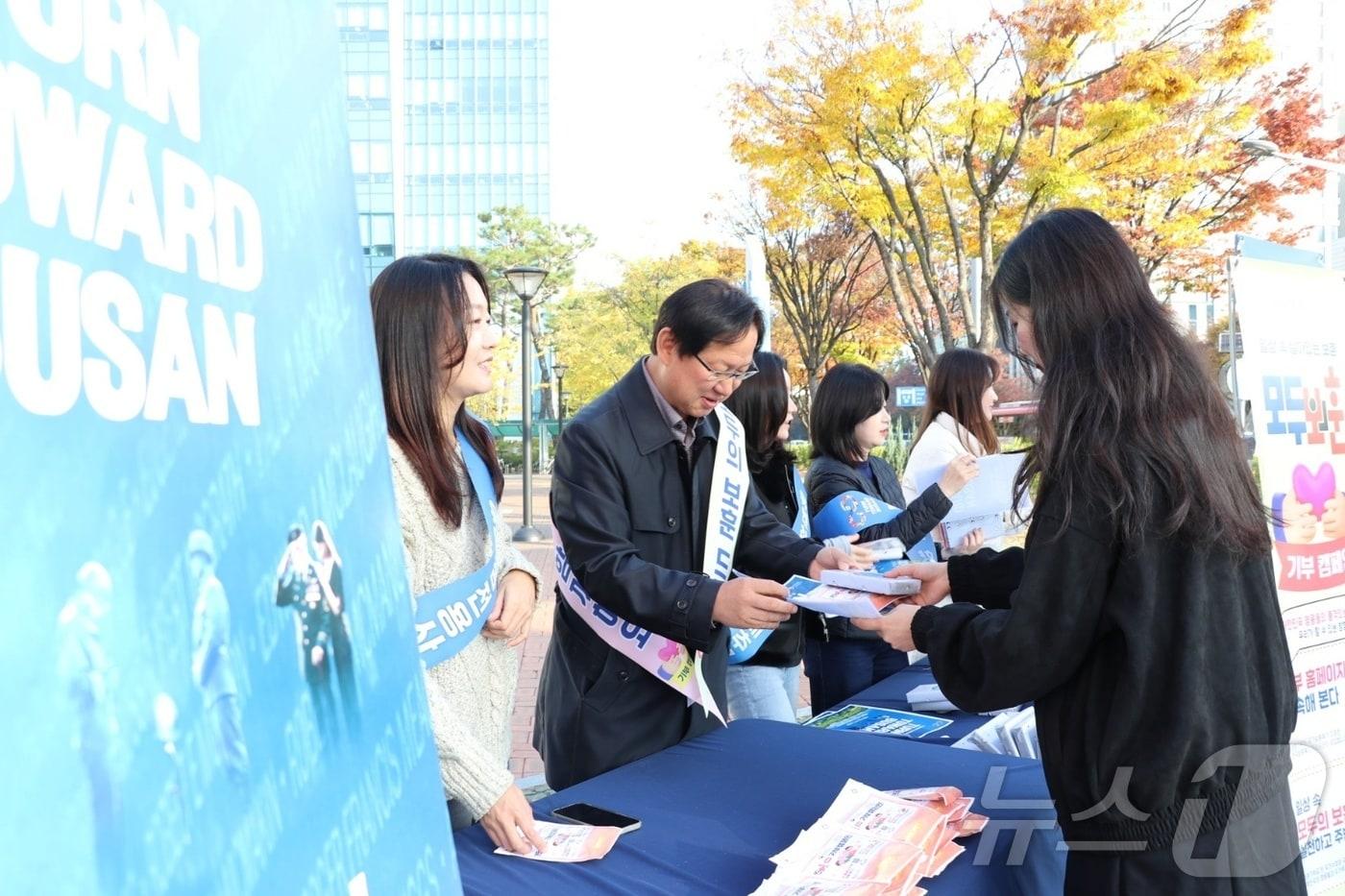  강만희 대전지방보훈청장&#40;왼쪽 두번째&#41; 이 11일 대전 정부청사 인근에서 시민들에게 &#39;턴 투워드 부산&#39; 홍보를 하고 있다. &#40;대전보훈청 제공&#41; /뉴스1 