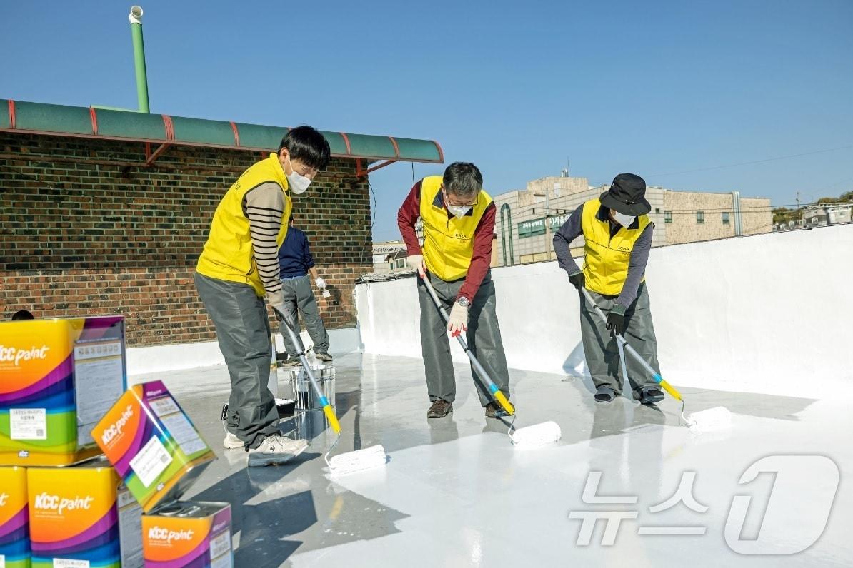 KCC와 서울시건축사회 관계자들이 쿨루프 작업을 하고 있다.&#40;KCC 제공&#41;