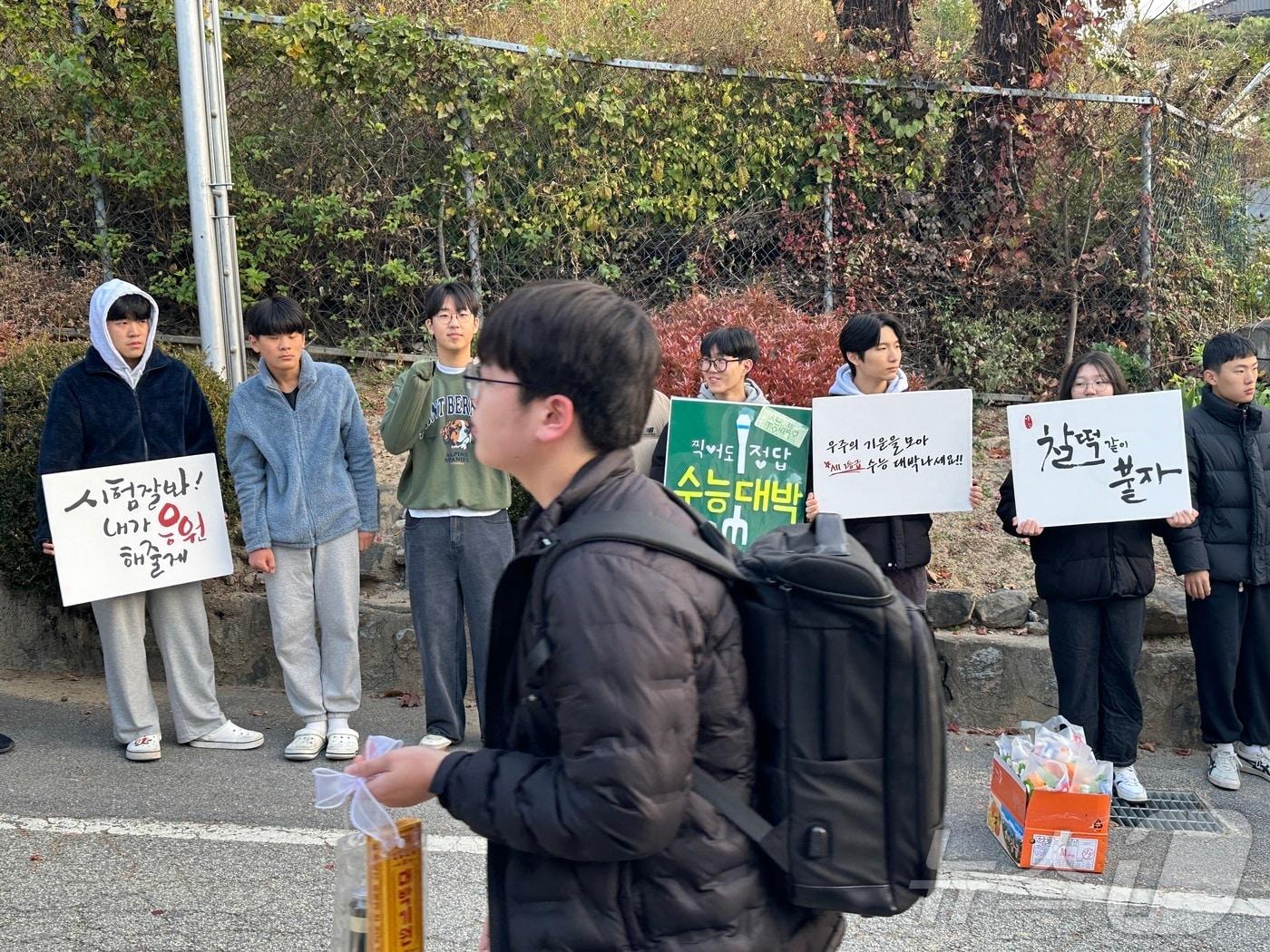 2025학년도 대학수학능력시험이 치러지는 충북 충주고등학교로 한 수험생이 무거워 보이는 가방을 맨 채 후배들의 응원을 받으며 긴장스런 표정으로 입장하고 있다.2024.11.14/뉴스1 ⓒ News1 윤원진 기자