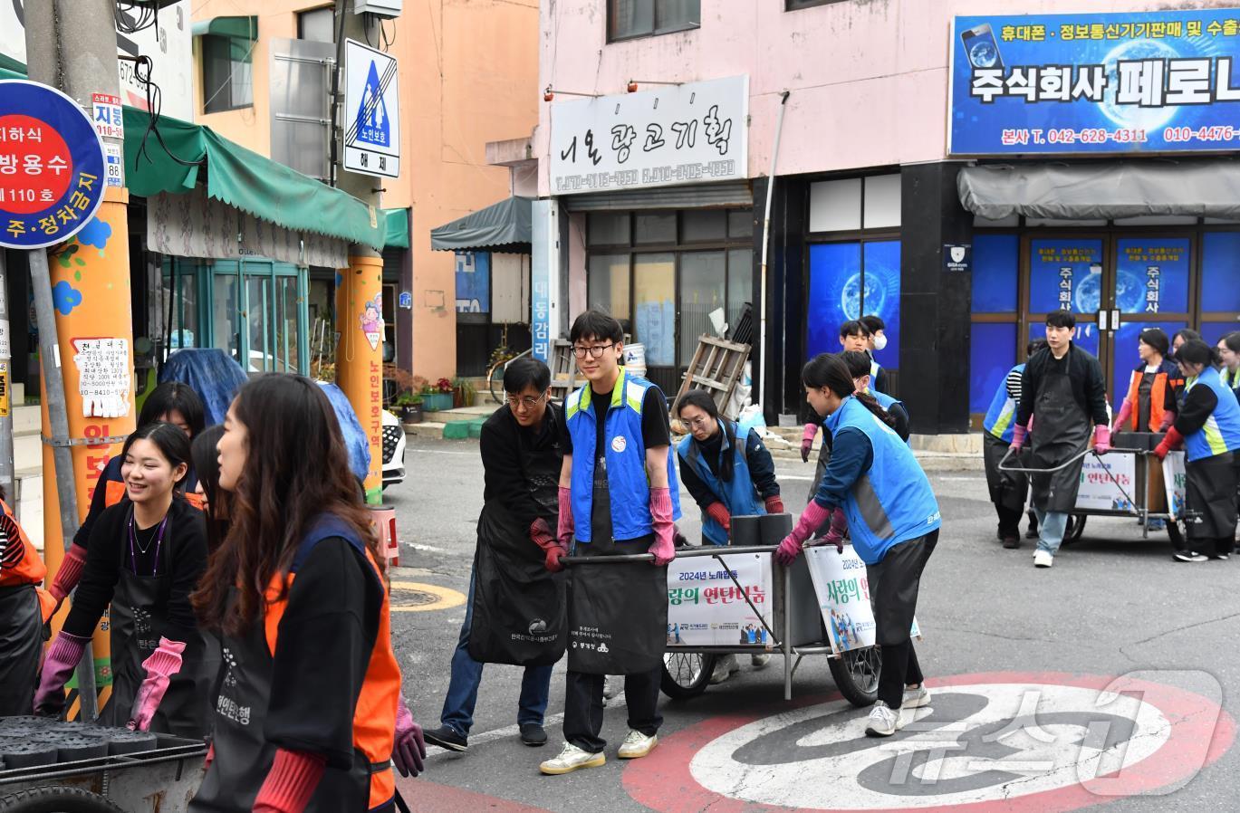 조폐공사와 한국가스기술공사, 소상공인시장진흥공단 직원들이 연탄을 나르고 있다.&#40;한국조폐공사 제공&#41;/뉴스1