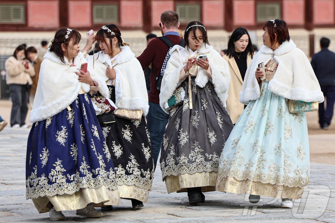 서울 종로구 경복궁에서 외국인 관광객들이 한복 위에 털망토를 두른 채 관람을 하고 있다. 2024.11.17/뉴스1 ⓒ News1 김도우 기자