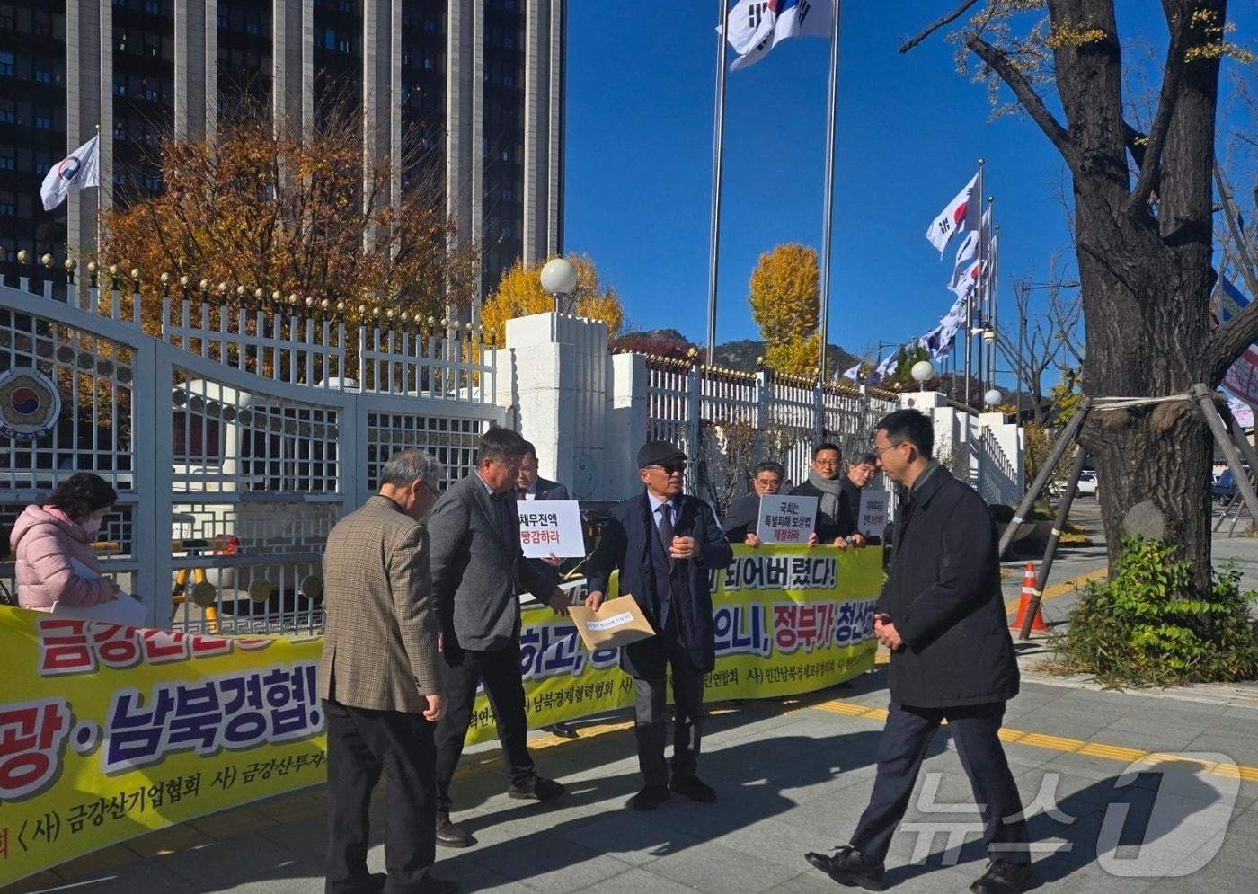 18일 남북경협단체연합회 등참석자들이 서울 종로구 정부서울청사에서 열린 금강산관광·남북경협 청산 촉구 기자회견에서 통일부 관계자에게 호소문을 전달하고 있다. 2024.11.18 /뉴스1