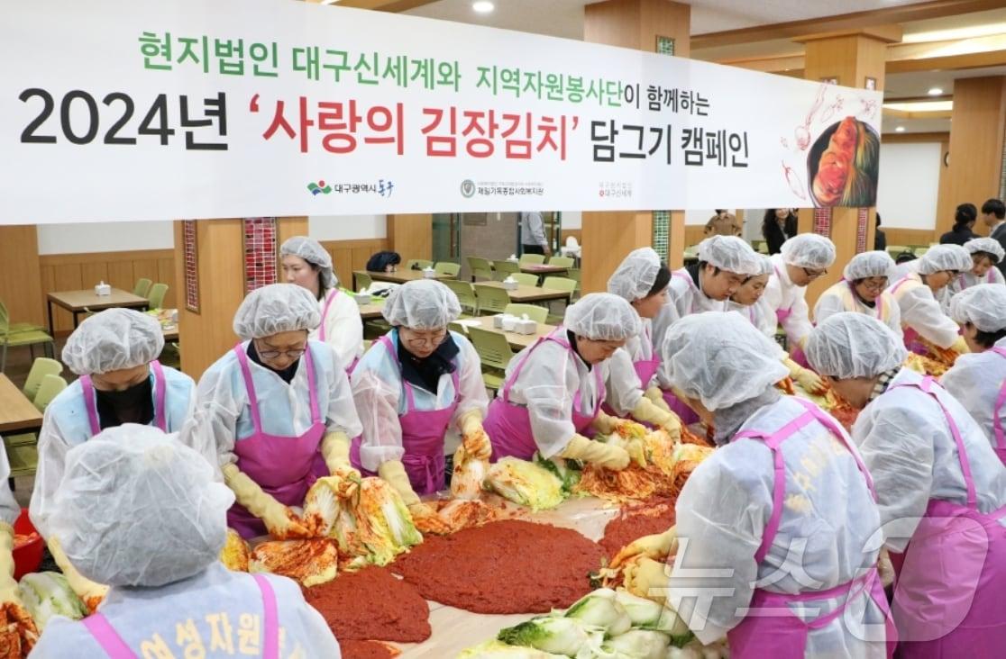 대구신세계백화점에 &#39;봉사 바이러스&#39;가 확산하고 있다. 사진은 지난 13일 진행한 사랑의 김장김치 담그기 캠페인에 참여한 직원들이 김치를 버무리는 모습.&#40;대구신세계 제공&#41;