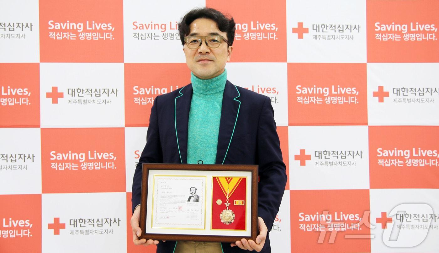 윤남호 롯데면세점제주 점장이 19일 제주 혼디누림터 대강당에서 열린 대한적십자사 창립 119주년 기념 연차대회에서 명예대장을 수상한 뒤 기념촬영을 하고 있다.&#40;롯데면세점제주 제공&#41;