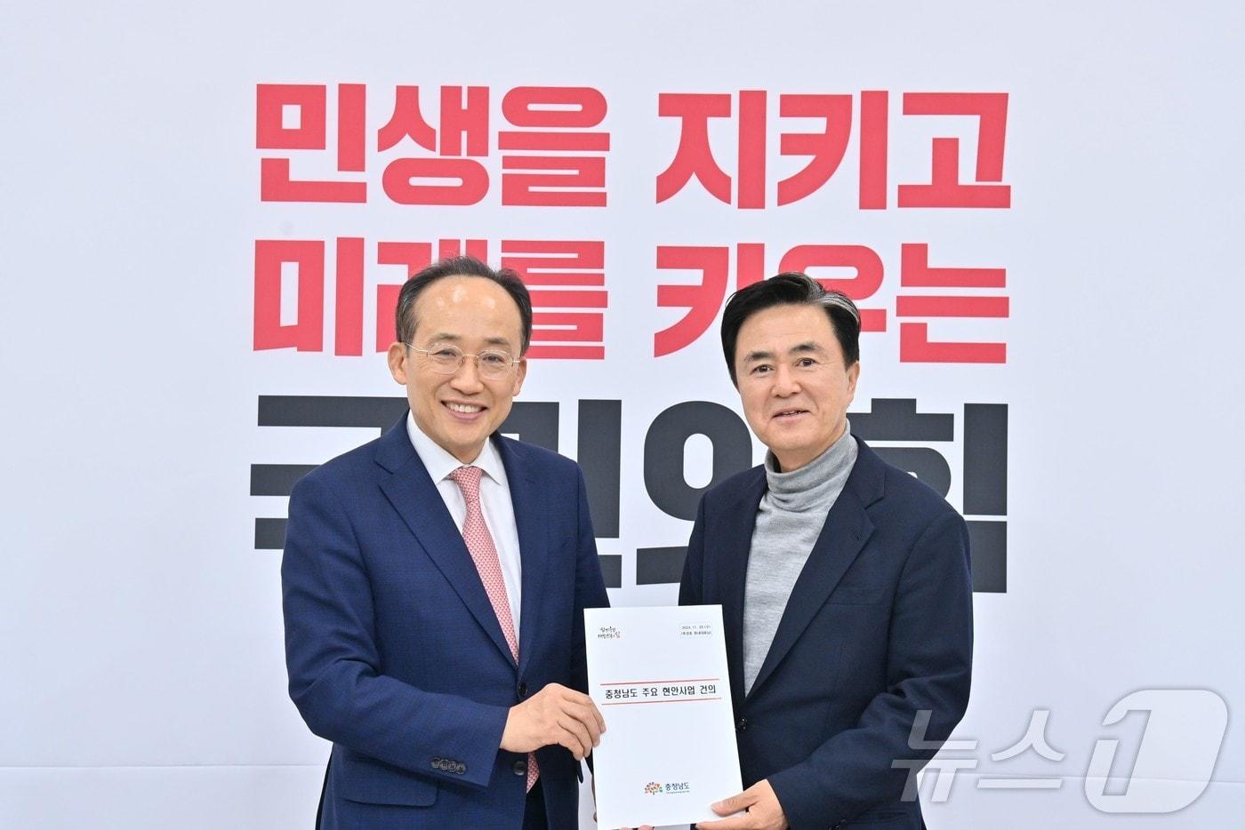 김태흠 지사&#40;오른쪽&#41;가 추경호 국민의힘 원내대표에게 충남 주요 현안 사업과 관련한 자료를 전달하고 기념촬영을 하고 있다.&#40;충남도 제공&#41; /뉴스1