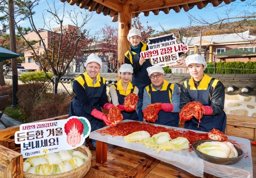  서울시 강남구 자곡동에 위치한 못골한옥어린이도서관에서 &#40;왼쪽 첫번째&#41;배하준 오비맥주 대표, &#40;왼쪽 세번째&#41;구자범 법무정책홍보부문 수석부사장, 임직원 봉사단이 김치를 만들며 기념사진을 촬영하고 있는 모습&#40;오비맥주 제공&#41;.