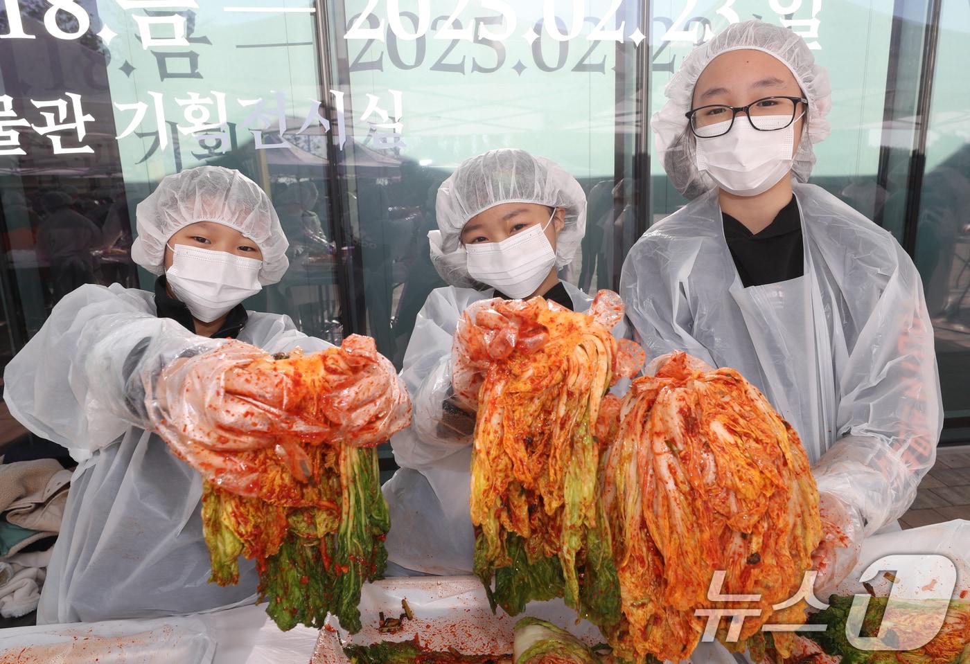 김치의 날인 22일 경기 수원시 권선구 국립농업박물관에서 열린 ‘배추는 사랑을 싣고!’ 김장 체험 프로그램에서 구운초등학교 학생들이 직접 심고 수확한 무와 배추로 담근 김장 김치를 들어보이고 있다. 이날 학생들이 담근 김장 김치 100통과 깍두기 50통은 권선구청을 통해 지역사회에 기부할 예정이다. 2024.11.22/뉴스1 ⓒ News1 김영운 기자