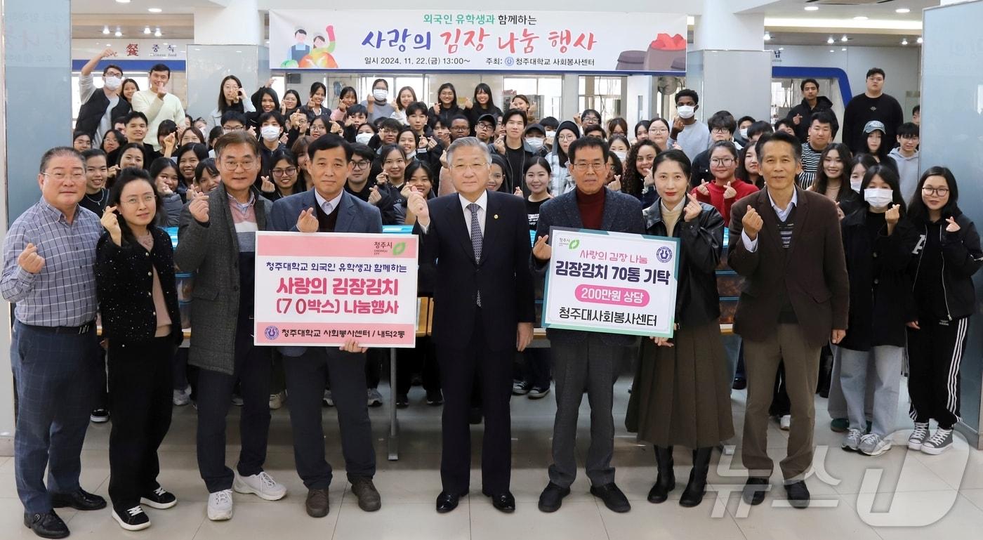 청주대학교 김윤배 총장&#40;오른쪽에서 4번째&#41;을 비롯한 교직원, 유학생들이 교내에서 &#39;사랑의 김장나눔 행사&#39;를 마친 뒤 기념 촬영을 하고 있다.&#40;청주대 제공&#41;/뉴스1