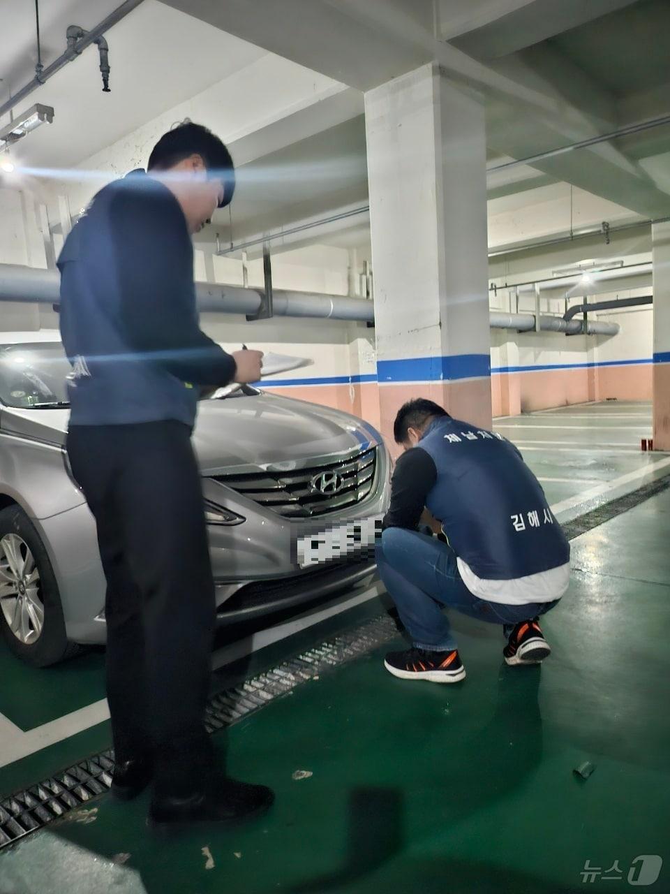 김해시 공무원들이 체납차량에 번호판 영치를 하는 모습.&#40;김해시 제공&#41;