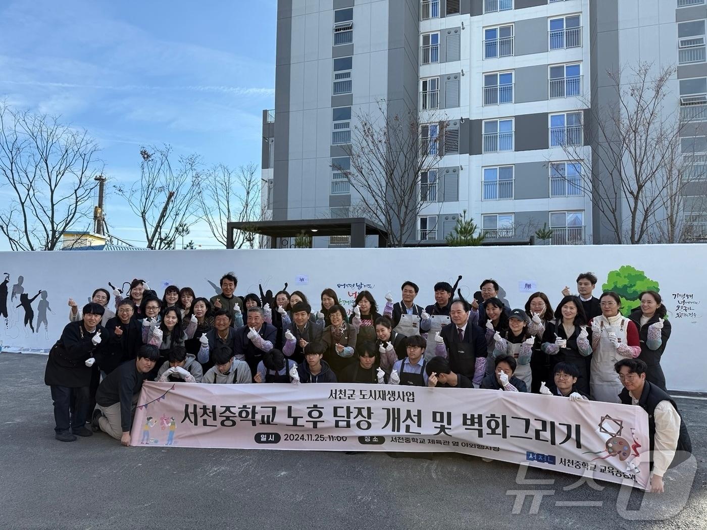 충남 서천중학교 노후 담장 개선 및 벽화그리기에 참여한 학생과 학부모, 기관 관계자들이 기념촬영을 하고 있다. &#40;서천군 제공&#41;/뉴스1