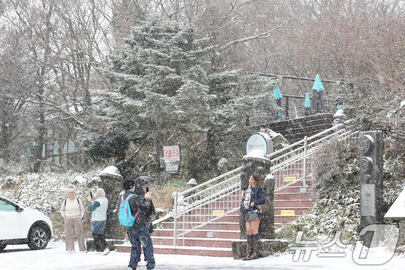 제주에 올가을 첫눈이 내린 27일 오전 한라산국립공원 1100고지휴게소에서 외국인 관광객들이 설경을 즐기고 있다. 2024.11.27/뉴스1 ⓒ News1 오현지 기자