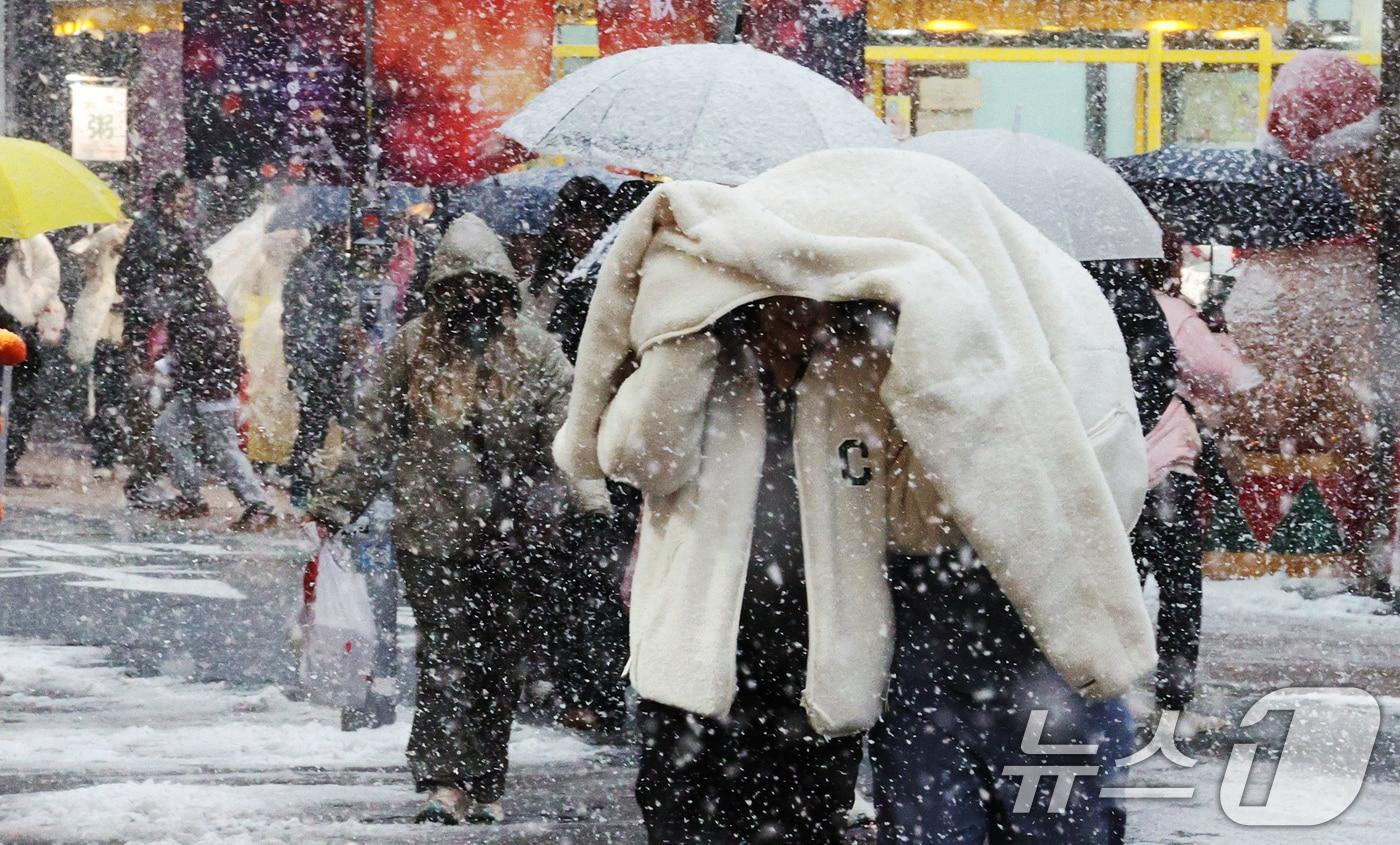 많은 눈이 내린 27일 오후 서울 명동에서 관광객들이 발걸음을 재촉하고 있다. 기상청은 기상관측을 시작한 이래 11월 가장 많은 눈이 내렸다고 밝혔다. 2024.11.27/뉴스1 ⓒ News1 장수영 기자