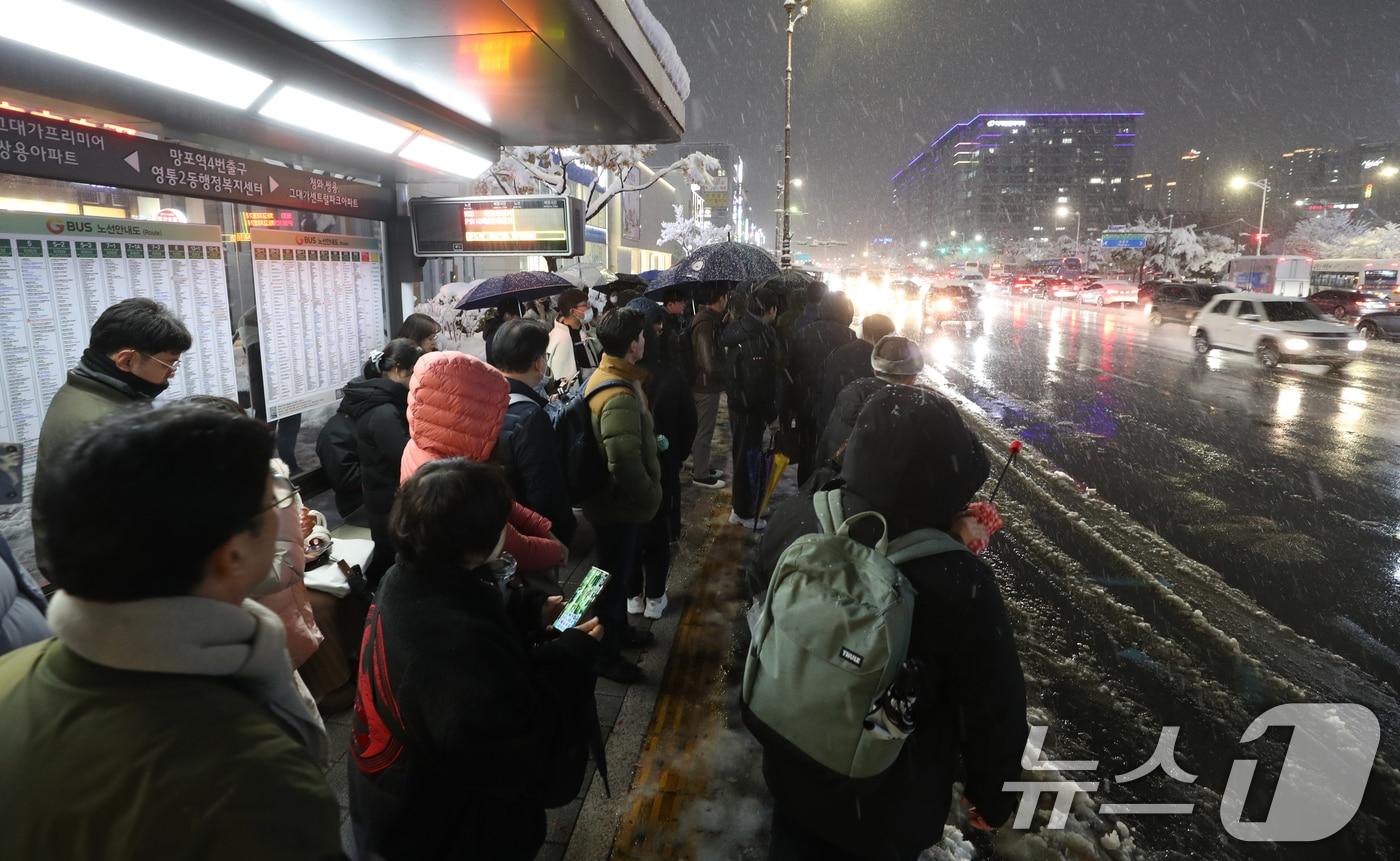 서울을 비롯한 수도권에 기록적인 폭설이 쏟아진 27일 오후 경기 수원시 영통구 망포역 사거리에서 퇴근길에 오른 시민들이 버스를 기다리고 있다. 2024.11.27/뉴스1 ⓒ News1 김영운 기자