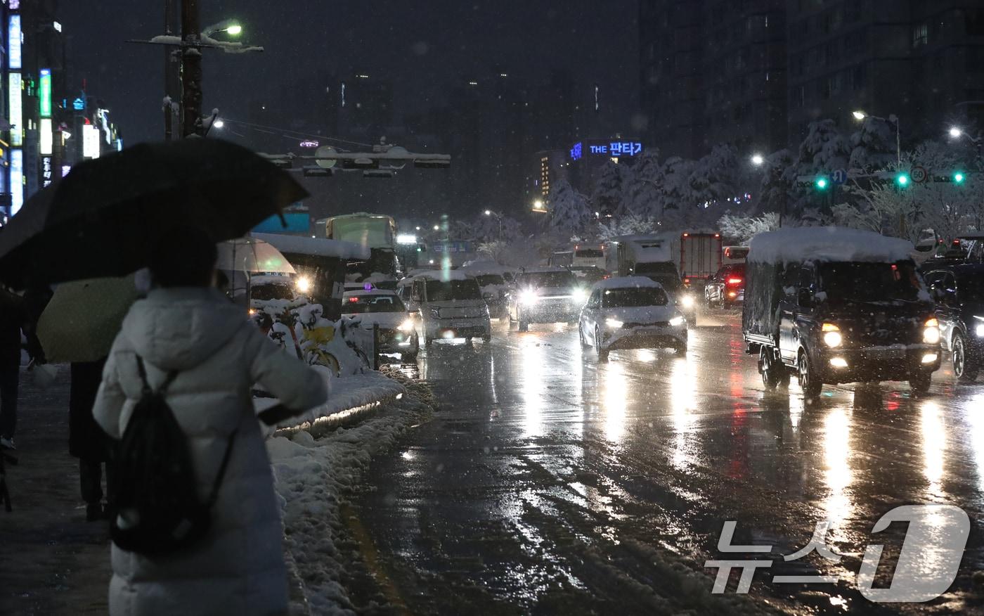 서울을 비롯한 수도권에 기록적인 폭설이 쏟아진 27일 오후 경기 수원시 영통구 망포역 사거리에서 퇴근길에 오른 시민들이 버스를 기다리고 있다. 2024.11.27/뉴스1 ⓒ News1 김영운 기자