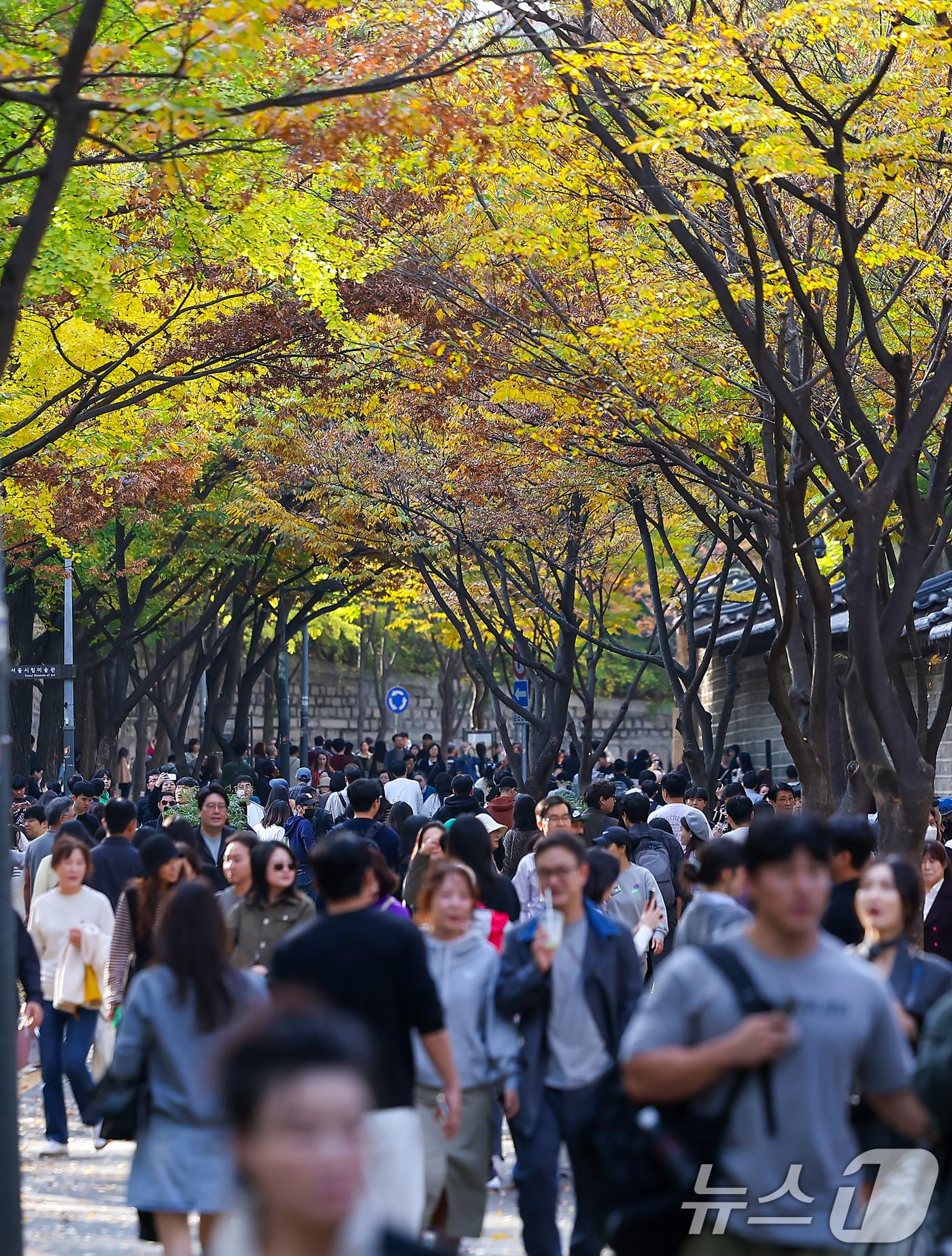 서울의 낮 최고기온이 24도 가까이 오르는 등 포근한 날씨를 보인 3일 오후 서울 중구 덕수궁 돌담길에 단풍이 물든 가운데 외국인 관광객들이 늦가을 정취를 즐기고 있다. 2024.11.3/뉴스1 ⓒ News1 김진환 기자