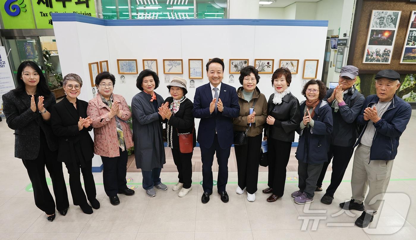 임택 광주 동구청장이 5일 오전 청사 로비에서 진행 중인 &#39;푸른 연필을 보았니&#39; 전시 참여자들과 기념 사진을 찍고 있다. &#40;광주 동구 제공&#41; 2024.11.5/뉴스1