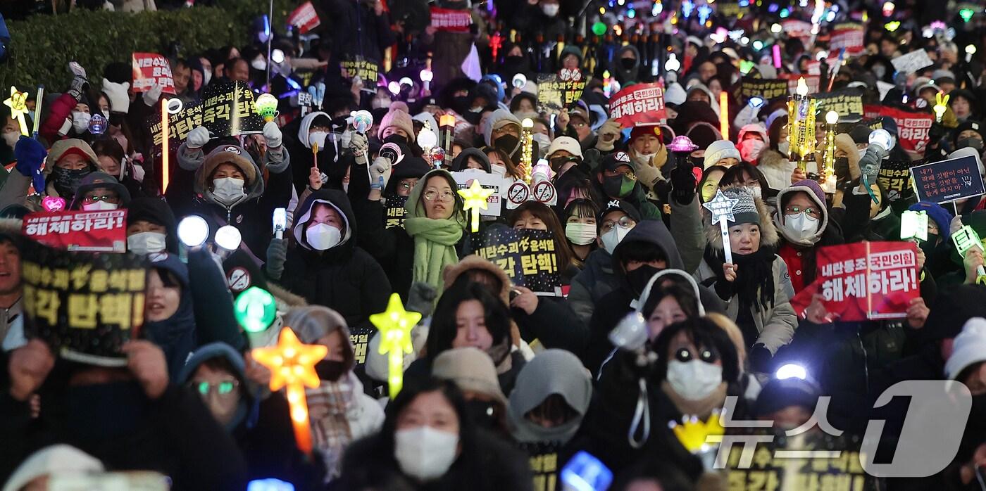 윤석열 대통령에 대한 국회의 2차 탄핵소추안 표결을 하루 앞둔 13일 오후 서울 영등포구 여의도 국회 앞에서 열린 &#39;윤석열 즉각 탄핵 구속 촉구 촛불문화제&#39;에서 참가자들이 응원봉과 손피켓을 들어 보이고 있다. 2024.12.13/뉴스1 ⓒ News1 김진환 기자