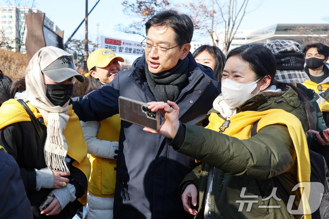 김경수 전 경남도지사가 14일 오후 서울 영등포구 여의도공원을 찾아 윤석열 대통령 탄핵 촉구 집회에 참가하는 시민들을 상대로 방한용품을 나눠준 노무현시민센터 관계자들을 만나 격려하고 있다. 2024.12.14/뉴스1 ⓒ News1 민경석 기자