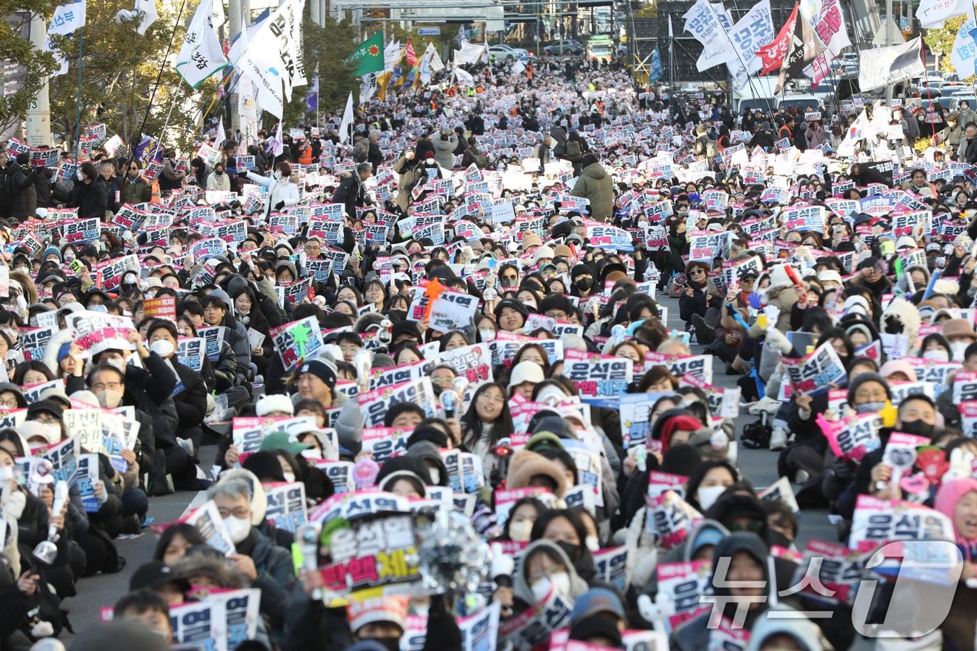 윤석열 대통령에 대한 탄핵소추안 표결을 앞둔 14일 오후 부산 부산진구 전포대로에서 열린 &#39;윤석열 탄핵·체포 부산시민대회&#39;에서 참가자들이 손피켓을 들고 구호를 외치고 있다. 2024.12.14/뉴스1 ⓒ News1 윤일지 기자