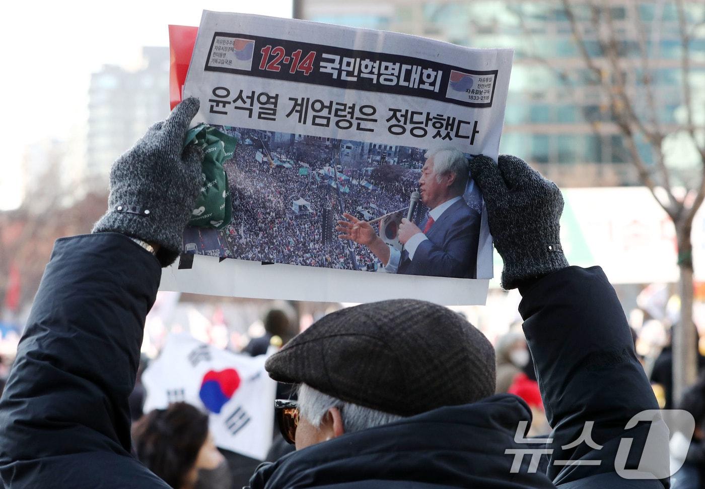 윤석열 대통령에 대한 국회 탄핵소추안 표결일인 14일 서울 세종대로 일대에서 대한민국살리기국민운동본부를 비롯한 보수단체 회원들이 ‘윤석열 계엄령은 정당했다’ 문구가 적힌 전단지를 들고 12·14 광화문 국민혁명대회에 참석하고 있다. 2024.12.14/뉴스1 ⓒ News1 박세연 기자