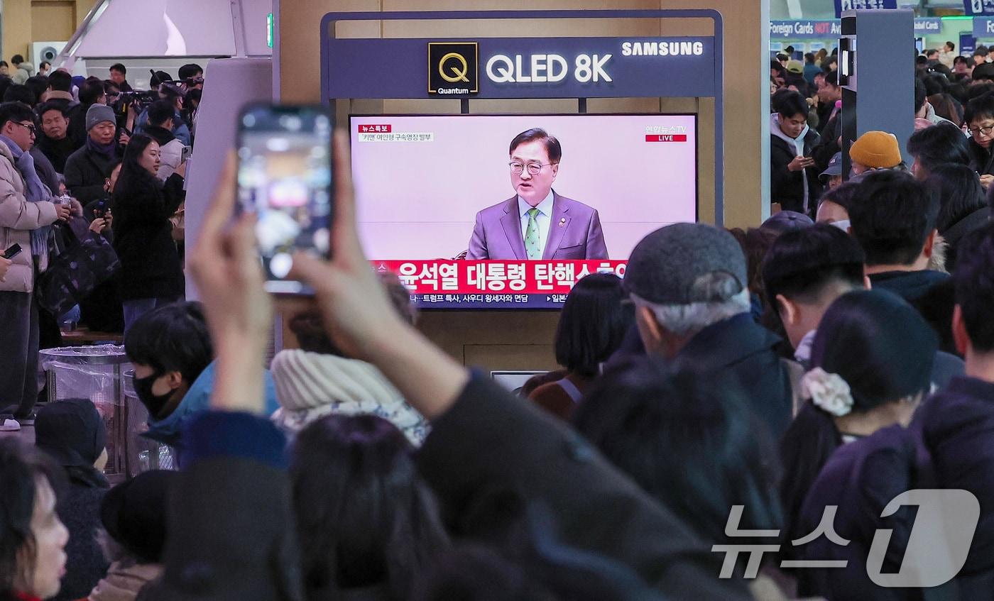 14일 서울 용산구 서울역 대합실에서 시민들이 윤석열 대통령에 대한 국회의 탄핵소추안이 가결되자 기뻐하고 있다. 이날 국회 본회의에선 재적의원 300명 전원이 투표에 참석, 이 중 204명 의원의 찬성으로 윤 대통령에 대한 탄핵소추안을 가결했다. 반대는 85명, 기권은 3표, 무효는 8표였다. 2024.12.14/뉴스1 ⓒ News1 김성진 기자