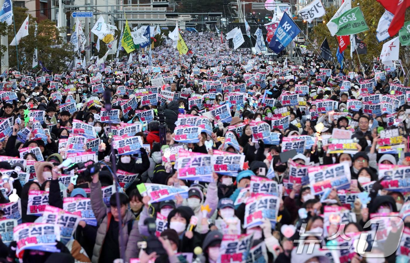 윤석열 대통령에 대한 탄핵소추안 표결일인 14일 오후 부산 부산진구 전포대로에서 열린 &#39;윤석열 탄핵·체포 부산시민대회&#39;에서 참가자들이 윤 대통령의 탄핵소추안이 가결되자 손피켓을 들고 환호하고 있다. 2024.12.14/뉴스1 ⓒ News1 윤일지 기자