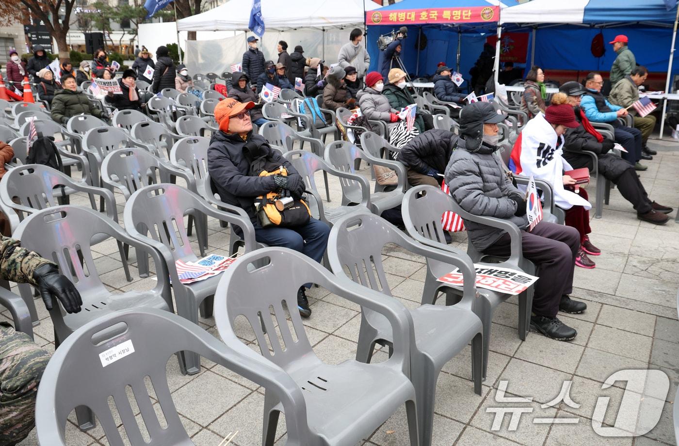 16일 서울 중구 동화면세점 앞에서 열린 자유통일당 탄핵반대 집회에서 참가자들이 국기에 대한 경례를 하고 있다. 2024.12.16/뉴스1 ⓒ News1 김명섭 기자