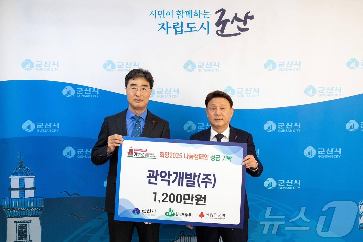 이해훈 관악개발 대표&#40;사진 왼쪽&#41;가 17일 강임준 군산시장에게 이웃돕기 성금 1200만원을 기탁하고 있다.&#40;군산시 제공&#41; 2024.12.17/뉴스1