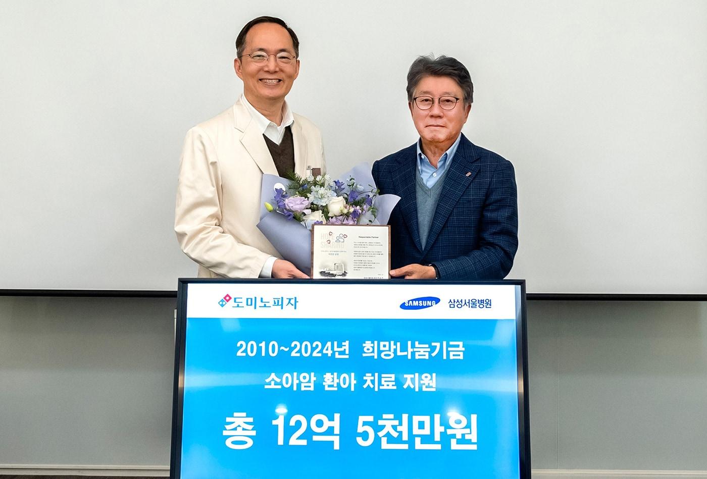 오광현 한국도미노피자 회장&#40;오른쪽&#41;이 박승우 삼성서울병원장과 17일 기부금 전달식에서 기념사진을 촬영하고 있다. &#40;한국도미노피자 제공&#41;