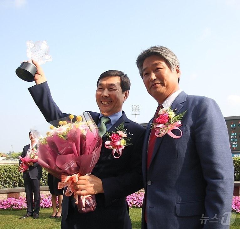 김영관 조교사&#40;왼쪽&#41;가 우승 트로피를 들어올리고 있다.&#40;렛츠런파크부산경남 제공&#41;