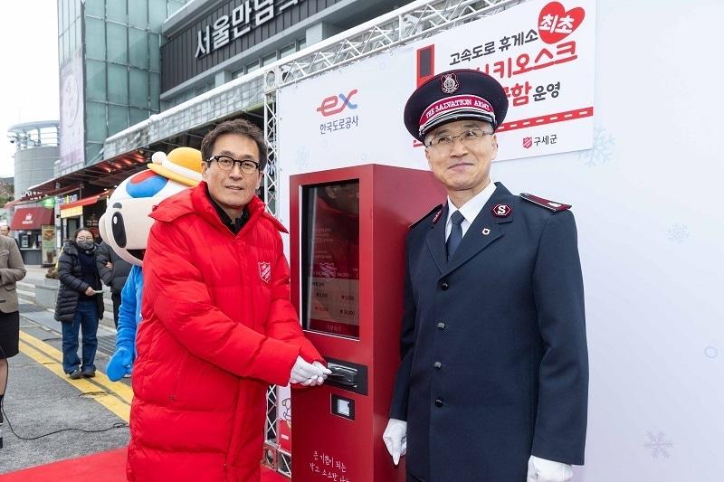 지난달 29일 서울 만남의 광장 키오스크 모금함 앞에서 함진규 한국도로공사 사장&#40;왼쪽&#41;&#41;과 김병윤 구세군 사령관&#40;오른쪽&#41;이 기념촬영을 하고 있다./도로공사 제공