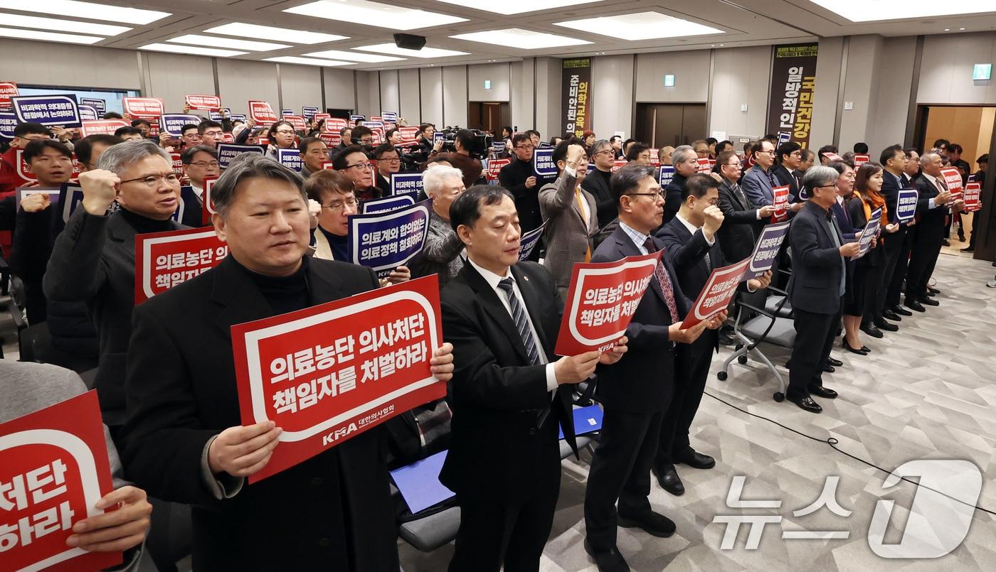 박형욱 대한의사협회&#40;의협&#41; 비상대책위원장을 비롯한 참석자들이 22일 오후 서울 용산구 의협회관에서 열린 전국의사대표자대회에서 손팻말을 들고 구호를 외치고 있다. 2024.12.22/뉴스1 ⓒ News1 구윤성 기자