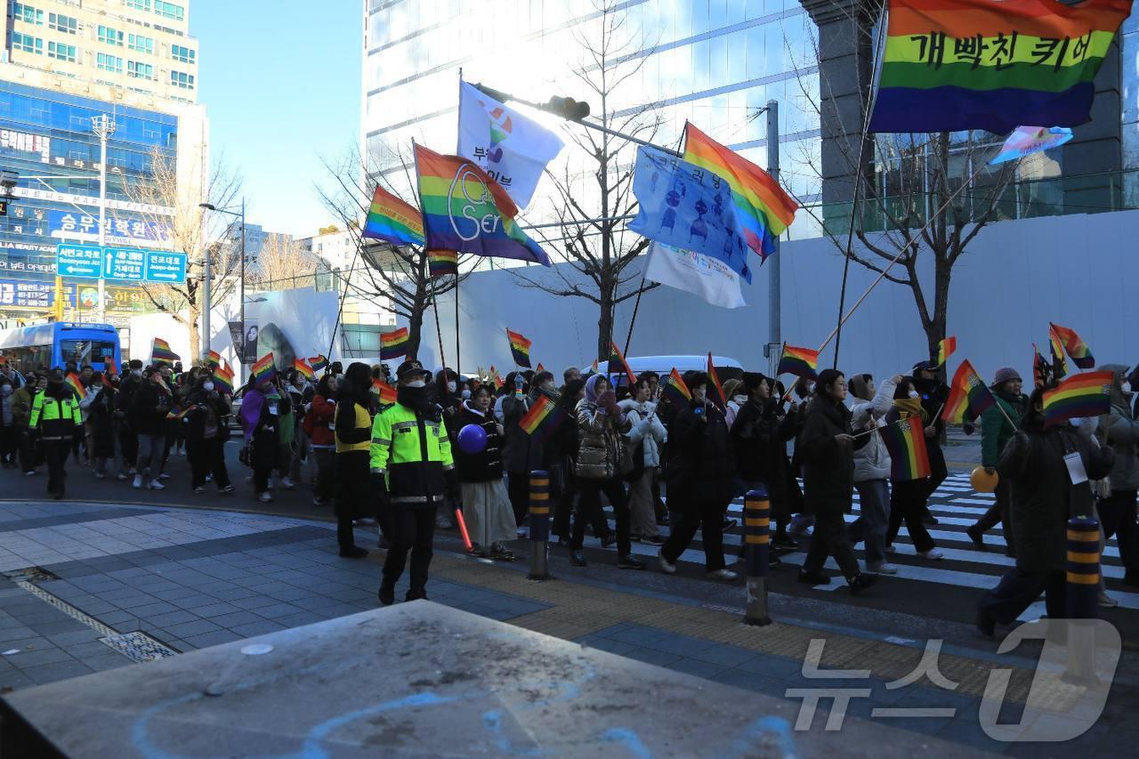 22일 오후 부산 부산진구 서면 일원에서 &#39;2024 메리퀴어스마스&#39; 행사 참가자들이 깃발을 들고 행진하고 있다.&#40;청년인권단체 아수나로 제공&#41;