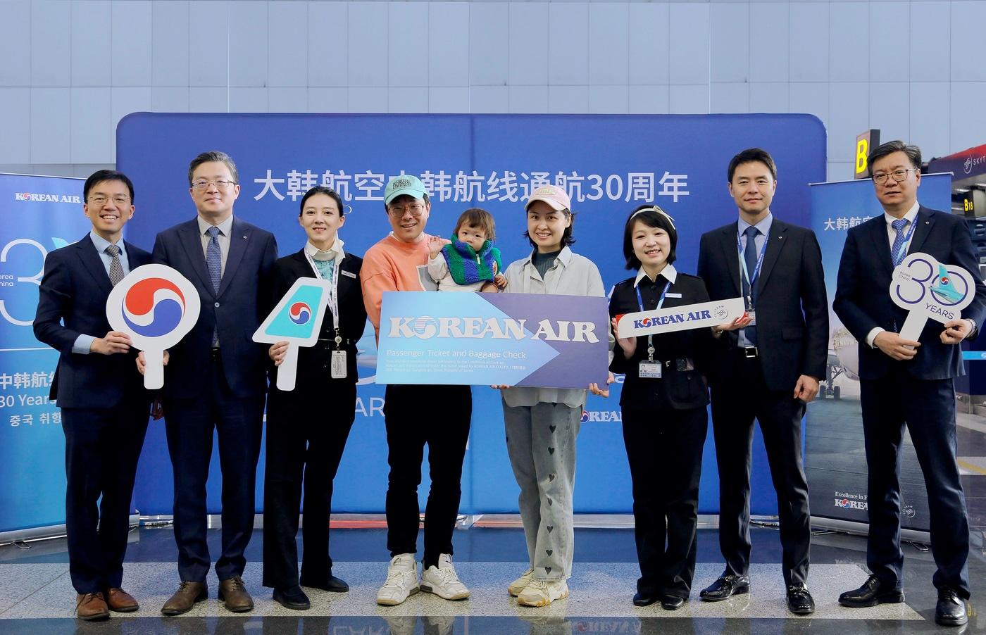 22일 베이징 서우두 국제공항에서 KE2202편 30번째 탑승수속 승객이 대한항공 한국행 왕복 비즈니스 항궁권 1매를 전달받고 관계자들과 기념사진을 촬영하고 있다&#40;대한항공 제공&#41;. 2024.12.22.