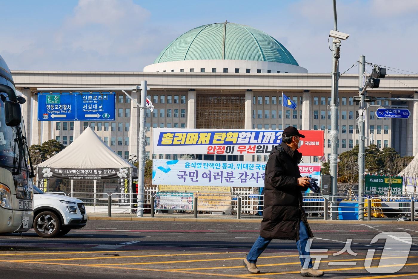 한덕수 대통령 권한대행에 대한 즉각적인 탄핵 절차에 나서려던 더불어민주당이 잠시 숨 고르기에 들어간 25일 서울 여의도 국회의사당 앞에 국민의힘과 진보당이 내건 현수막이 걸려 있다. 2024.12.25/뉴스1 ⓒ News1 안은나 기자