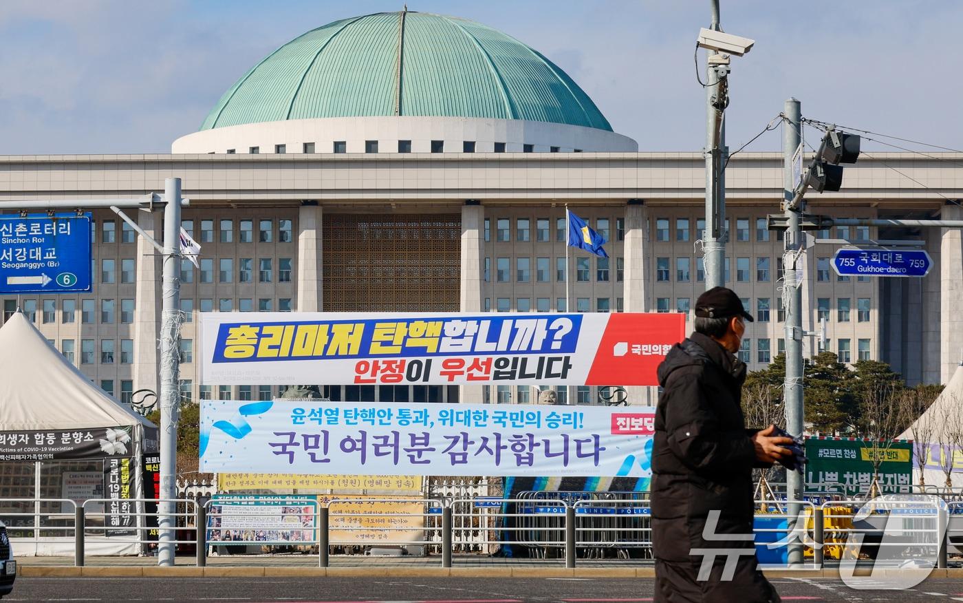 한덕수 대통령 권한대행에 대한 즉각적인 탄핵 절차에 나서려던 더불어민주당이 잠시 숨 고르기에 들어간 25일 서울 여의도 국회의사당 앞에 국민의힘과 진보당이 내건 현수막이 걸려 있다. 2024.12.25/뉴스1 ⓒ News1 안은나 기자