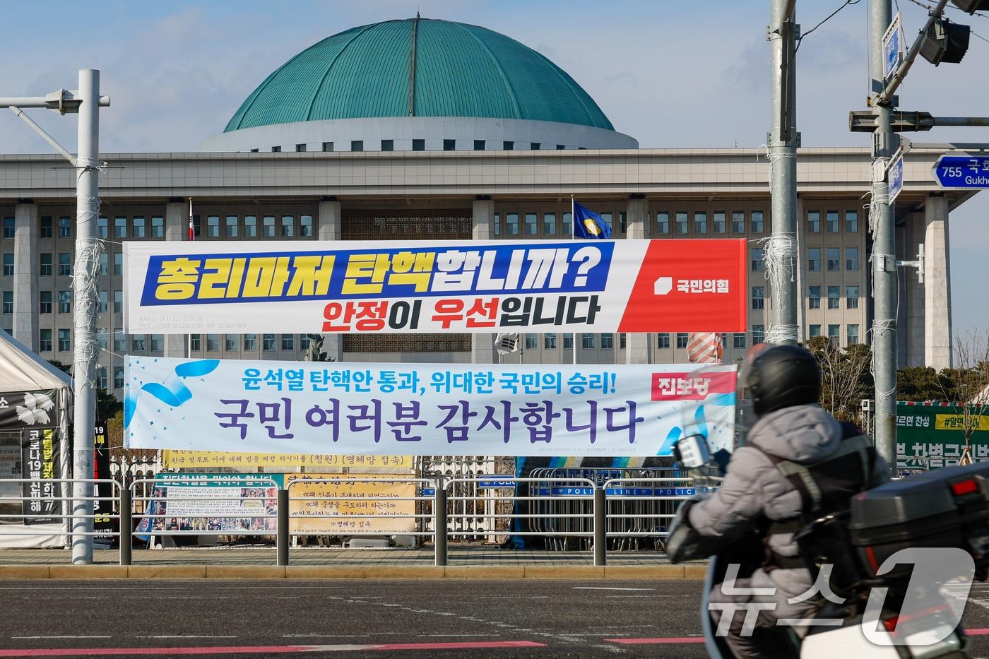 한덕수 대통령 권한대행에 대한 즉각적인 탄핵 절차에 나서려던 더불어민주당이 잠시 숨 고르기에 들어간 25일 서울 여의도 국회의사당 앞에 국민의힘과 진보당이 내건 현수막이 걸려 있다. 2024.12.25/뉴스1 ⓒ News1 안은나 기자