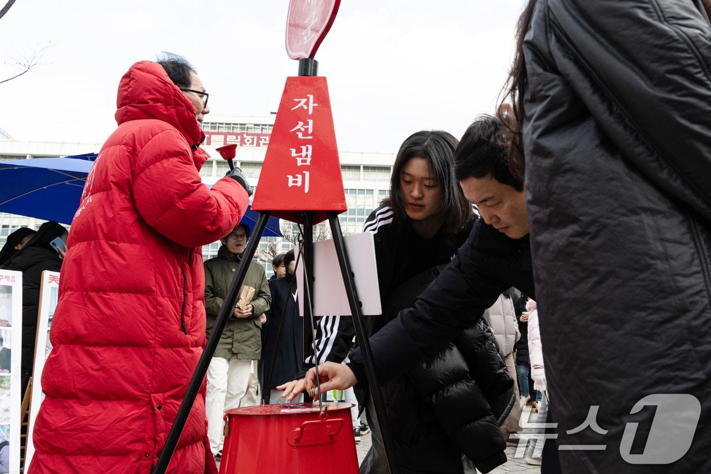 성탄절인 25일 오후 서울 중구 명동거리에서 시민들이 구세군 자선냄비에 기부하고 있다. 2024.12.25/뉴스1 ⓒ News1 이승배 기자