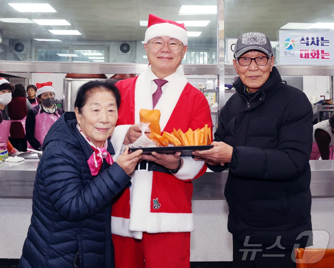 칠곡군 무료 급식소 칠곡사랑의집을 이용하는 어르신들이 26일 자신보다 어려운 이웃을 돕기 위해 모은 성금을 김재욱 군수에게 전달하고 있다.&#40;칠곡군 제공&#41; 2024.12.26/뉴스1