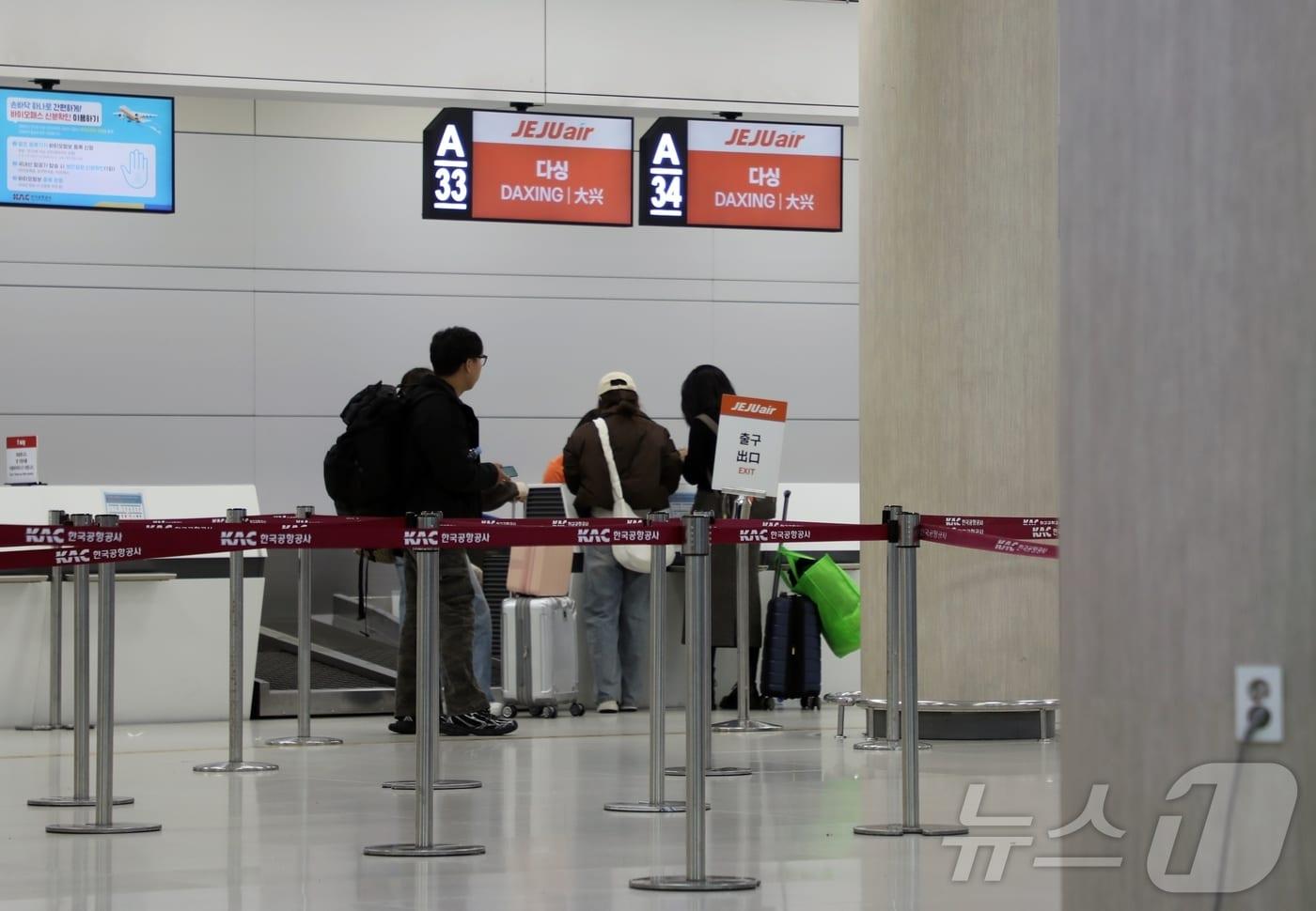 29일 제주국제공항 3층 제주항공 탑승수속장에서 베이징 다싱행 항공편 탑승객들이 결항 안내를 받고 있다.2024.12.29/뉴스1