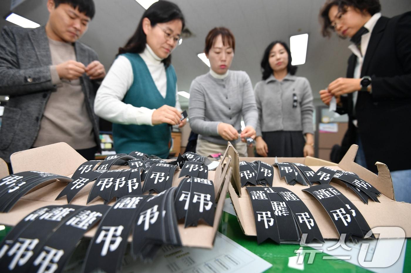 30일 경북 포항시청에서 공무원들이 전남 무안 제주항공 여객기 사고로 목숨을 잃은 분들의 명복을 빌기 위해 추모 리본을 달고 있다. 포항시는 시 소속 모든 공무원들과 함께 아픔을 나누기 위해 추모리본을 배부했다. 2024.12.30/뉴스1 ⓒ News1 최창호 기자